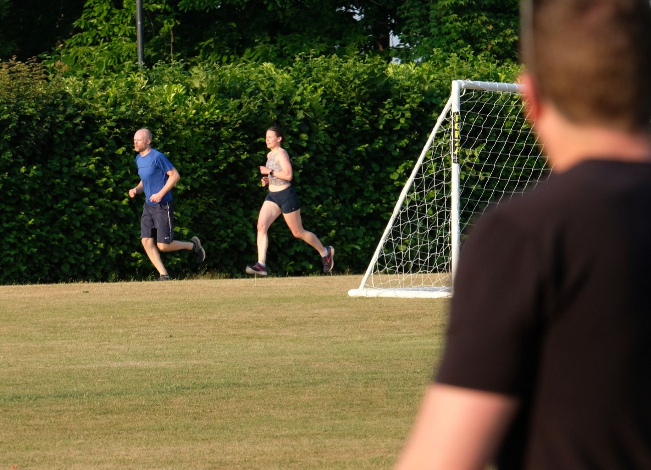 trainer watching man and woman running